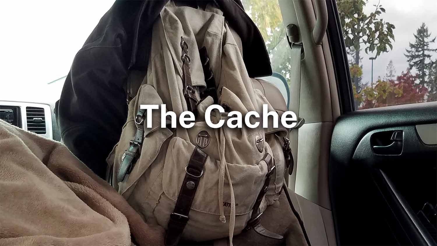 A packed canvas backpack in a vehicle, representing a cache: a store of items kept close and ready, but opaque until you look inside